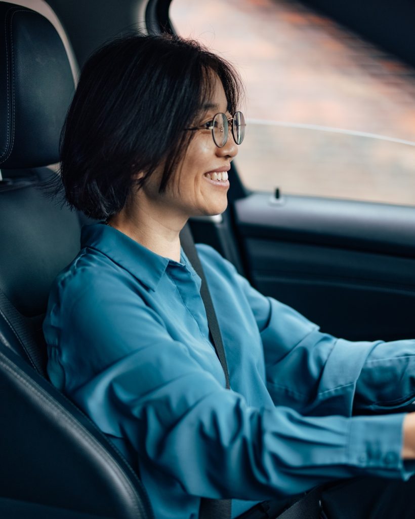 Happy businesswoman driving a car.
