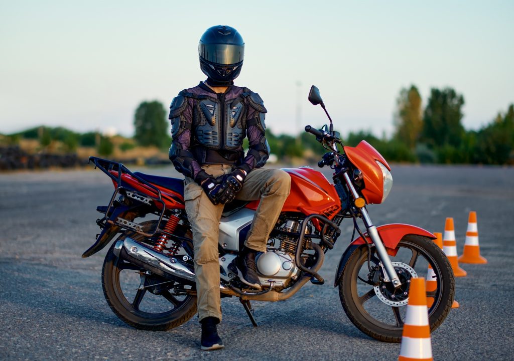 Male student poses on motorbike, motorcycle school